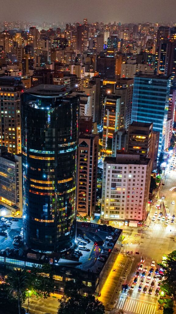 Vibrant aerial view of São Paulo's illuminated skyline, highlighting modern architecture and bustling city life.
